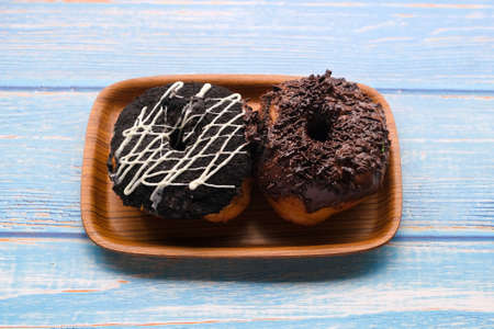 Fresh baked glazed donuts on a wooden tableの写真素材
