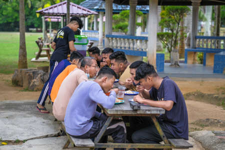 Muadzam Shah, Malaysia - October 14th,2020:  Students and teacher  eating lunch together under the treeのeditorial素材