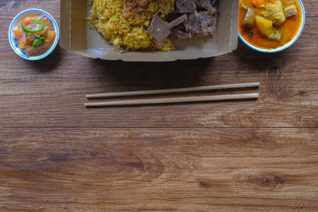 Top view of roasted meat served with rice , dalca and sour sauce . This food is well-known in the Northern Peninsular Malaysia known as " Nasi Daging Air Asam"の写真素材