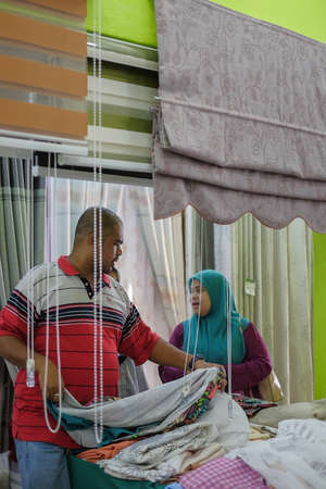 Nilai, Malaysia - July 13th, 2019 : Mother and daughter  choosing a curtain in  textiles shopのeditorial素材