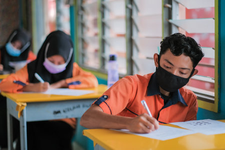 Muadzam Shah, Malaysia -January 20th,2021: Malaysian students wear face shields and facemasks in classroomfor protect from Covid -19. New normal education.のeditorial素材
