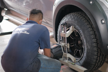 Kuala Lumpur , Malaysia - June 29th, 2020 : Tyre allignment on the car in a workshop by a mechanic.のeditorial素材
