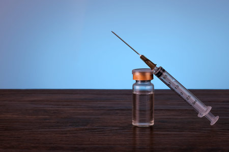 Syringe, bottle and money in budget cost money concept spend to health with light blue background