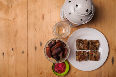 Traditional Islamic Ramadan or Ramazan Iftar food. Flat-lay of dates and fresh drinking water with Murtabak on wooden  background, top view. Ramadan muslim fasting monthの写真素材