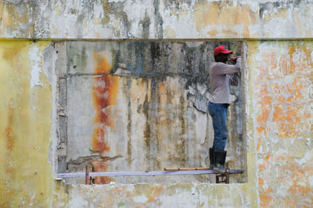 Demolition work and rearrangement. worker with sledgehammer destroying wallのeditorial素材