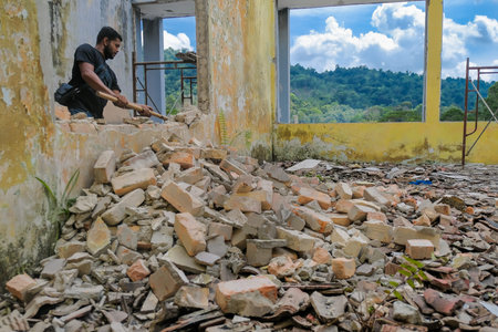 Demolition work and rearrangement. worker with sledgehammer destroying wall