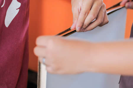 Young carpenters installing laminate for built-in  cabinets at the workshopの写真素材