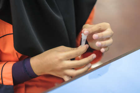 Muadzam Shah, Malaysia - October 31th, 2021 : Lateral-Flow-Test covid rapid home-use test kit for saliva - step 2 - spit with mouth through funnel in plastic tube to collect sample.のeditorial素材
