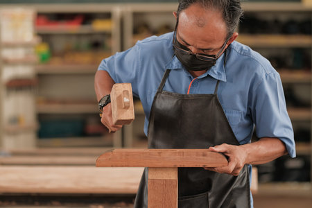 Carpenter working in his workshop using a circular saw to cut woodの写真素材