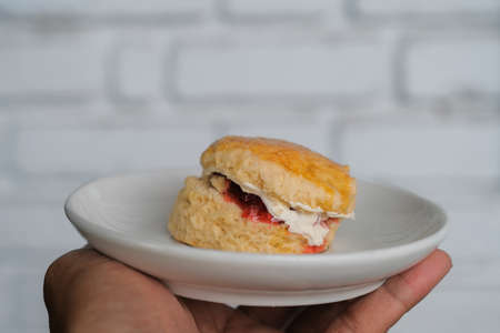 Scone with strawberry jam and clotted cream.の写真素材