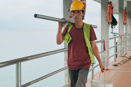 Tioman, Malaysia- 20 April 2022 : Construction worker is assembly scaffolding above sea water for repair a concrete jetty.のeditorial素材