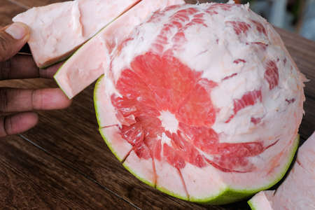 Fresh red pomelo fruit or grapefrui on wooden backgroundの写真素材