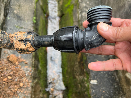 old water pipe with valve in hand, closeup of photo.