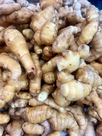 Close up of fresh ginger root for sale at a market stall.