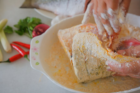 Hands of woman chef preparing fish foodの写真素材