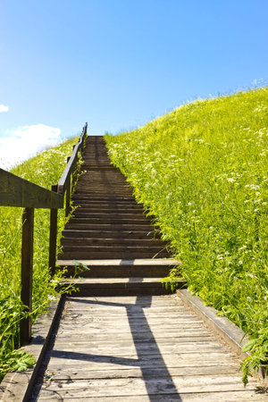 Stairs to blue sky on green hill. Abstract natural backgrounds. Vertical image