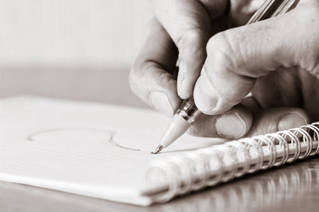 Notebook with question. Hand with pen. Image toned in black and white colors