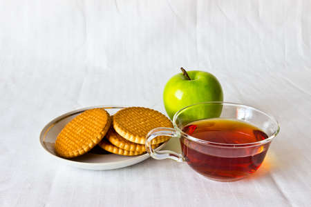 Strong black ceylon tea with cookies and fresh apple at white backgroundの写真素材