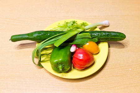 Fresh vegetables on yellow plateの写真素材
