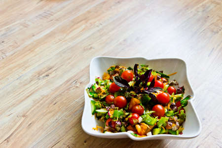 Fresh vegetable salad with basil leaves in ceramic bowl. Selective focusの写真素材
