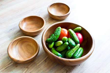 Fresh vegetables in big wooden bowl with small empty bowlsの写真素材
