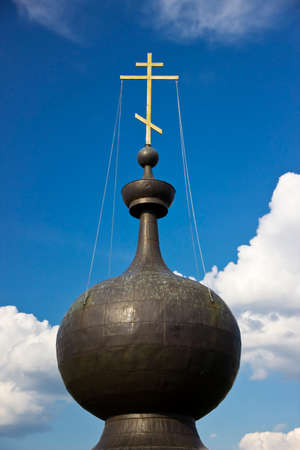 Black dome witn golden cross at the blue skyの写真素材