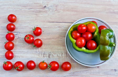 Fresh vegetables on wooden background. Conceptual image with tomatoes frameの写真素材