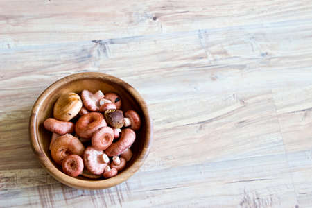 Mushrooms in wooden bowl. Object at the left part of imageの写真素材