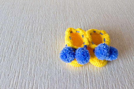 Colorful wool baby shoes on white background. Objects at the right part of imageの写真素材