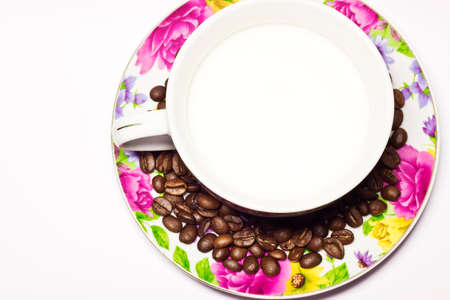 Coffee beans on colorful plate with cup of milkの写真素材
