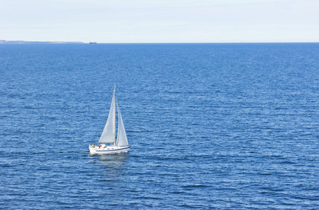 Sailing ship yachts with white sails in the sea near coastline of Tallinn, Estoniaの写真素材