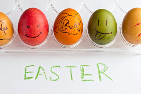 Colored easter eggs with smile faces and question on stand. Green sign EASTER. Top view. Isolated on...
