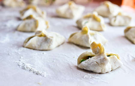 Cooking homemade puff pastry cakes with onion and egg. Focus on foreground, blurred backgroundの写真素材