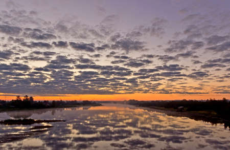 Beautiful summer landscape with tranquility sunrise over the foggy riverの写真素材