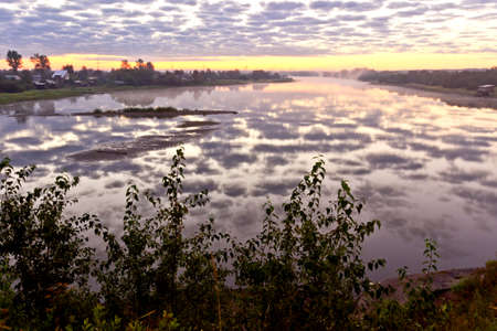 Beautiful summer landscape with tranquility sunrise over the foggy riverの写真素材
