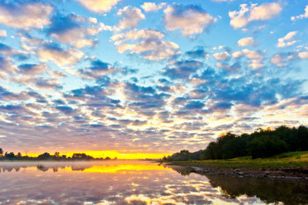 Beautiful summer sunrise with fog over the river and dramatic sky
