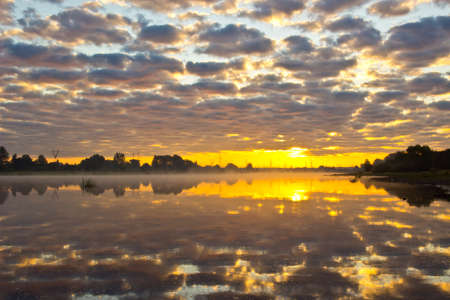 Beautiful summer sunrise with multicolored sky over the riverの写真素材