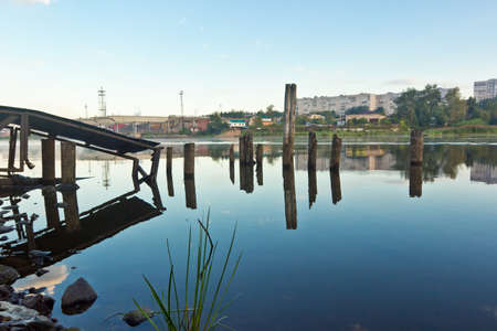 Old broken pier in river at sunriseの写真素材