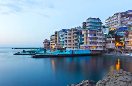 Modern resort place with many illuminated mini hotels, called Santa-Barbara in Utes, Crimea, beautiful sunriseのeditorial素材