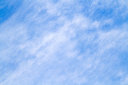 thin white cloud spread over a blue skyの写真素材