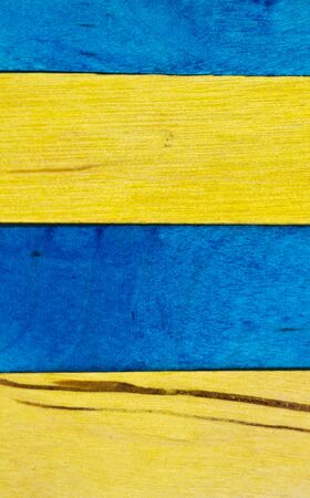 horizontal arrangement of blue and yellow wood in portrait orientationの写真素材