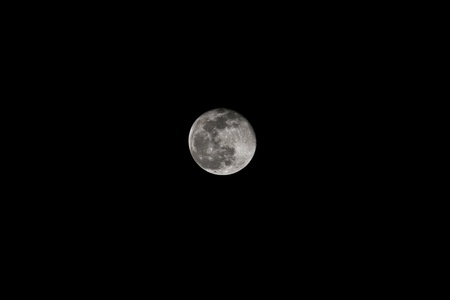Near full moon with dark background as seen through 400mm lensの写真素材