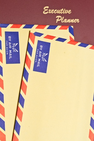 a dark red executive planner with two yellow color envelopes in portrait orientationの写真素材