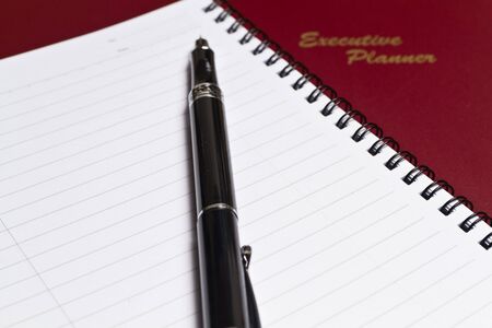 a brown executive planner with spiral note book and a pen in lanscape orientationの写真素材