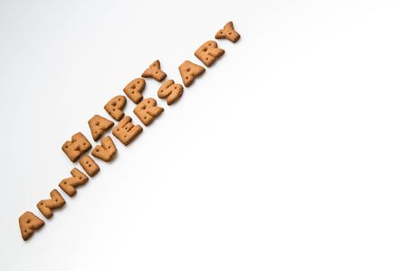 Happy anniversary wording made by brown biscuits slanting on white surface in landscpe orientationの写真素材