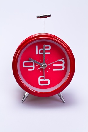 close up of red clock face on white background in portrait orientationの写真素材