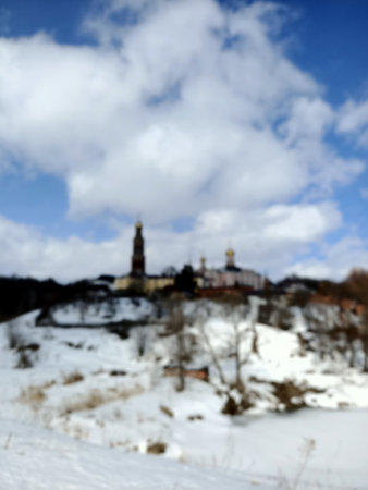 Walls, bill towers and churches of old medieval monastery in white snows ander the blue winter skyの写真素材