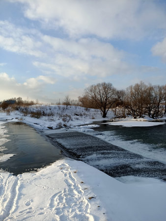 Snowed river and bank in winter cold season