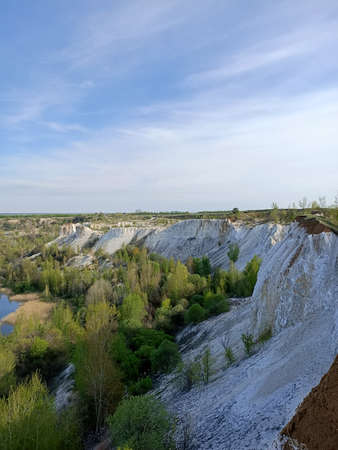 Aerial view of limestone quarry with blue sky and green trees.の写真素材