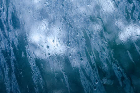 Rain drops on a windowpane in cloudy weatherの写真素材